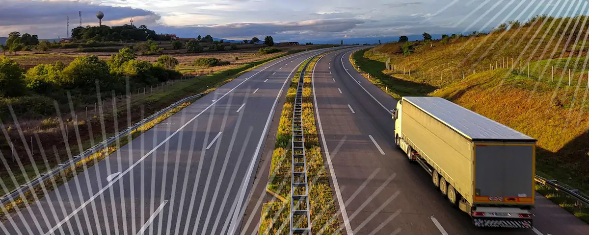 A semi-trailer driving down an empty highway.